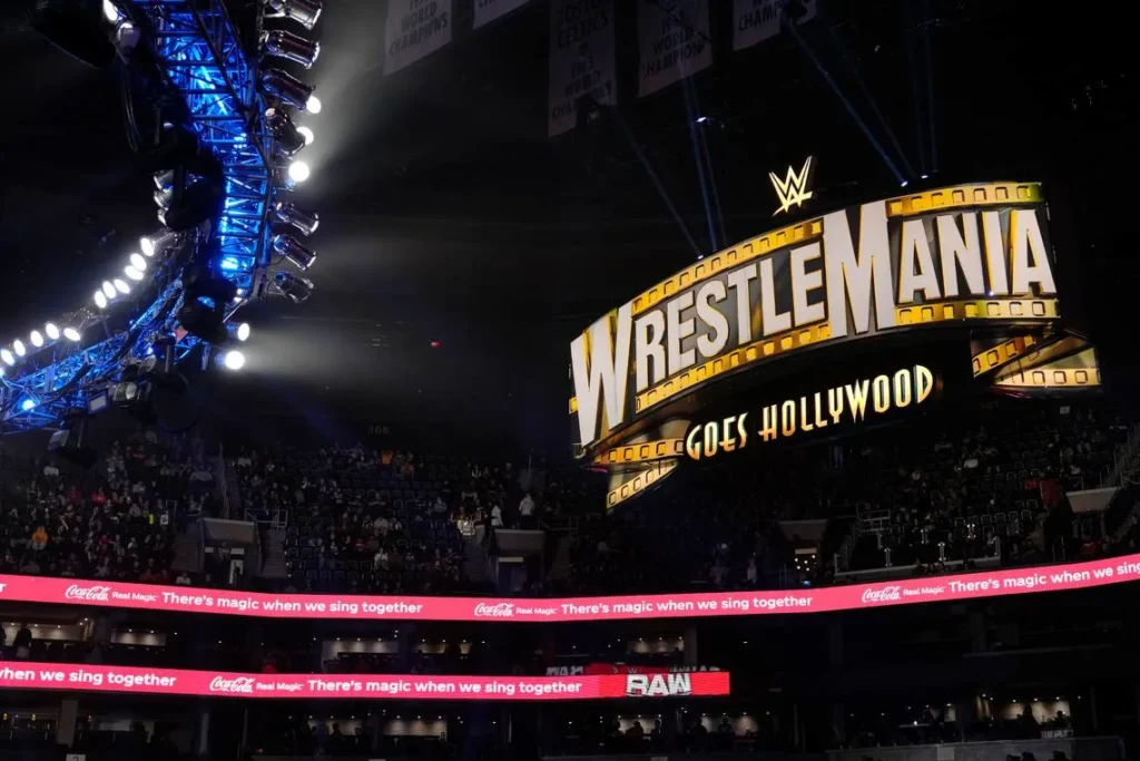 9cacfd81a4b7bdf61a5eb800173e1461 WrestleMania Goes Hollywood arena setup with large illuminated sign and blue stage lighting at WWE event