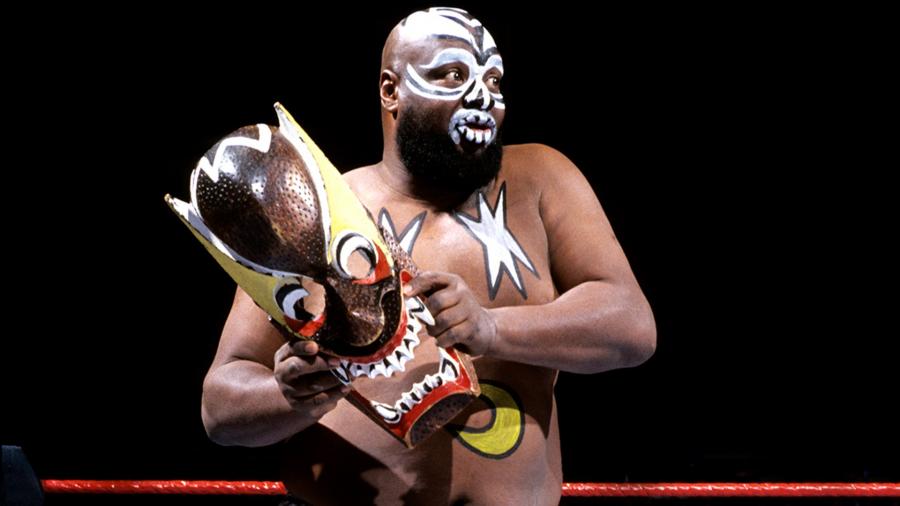 Kamala Kamala 'The Ugandan Giant' WWE wrestler in face paint and tribal costume holding decorative mask during 1980s wrestling era
